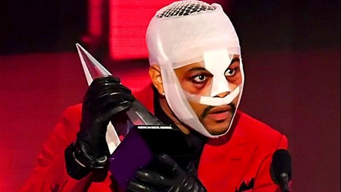 the weeknd performs with a face bandage